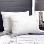 Two white pillows with subtle patterns on a bed in a bedroom setting.