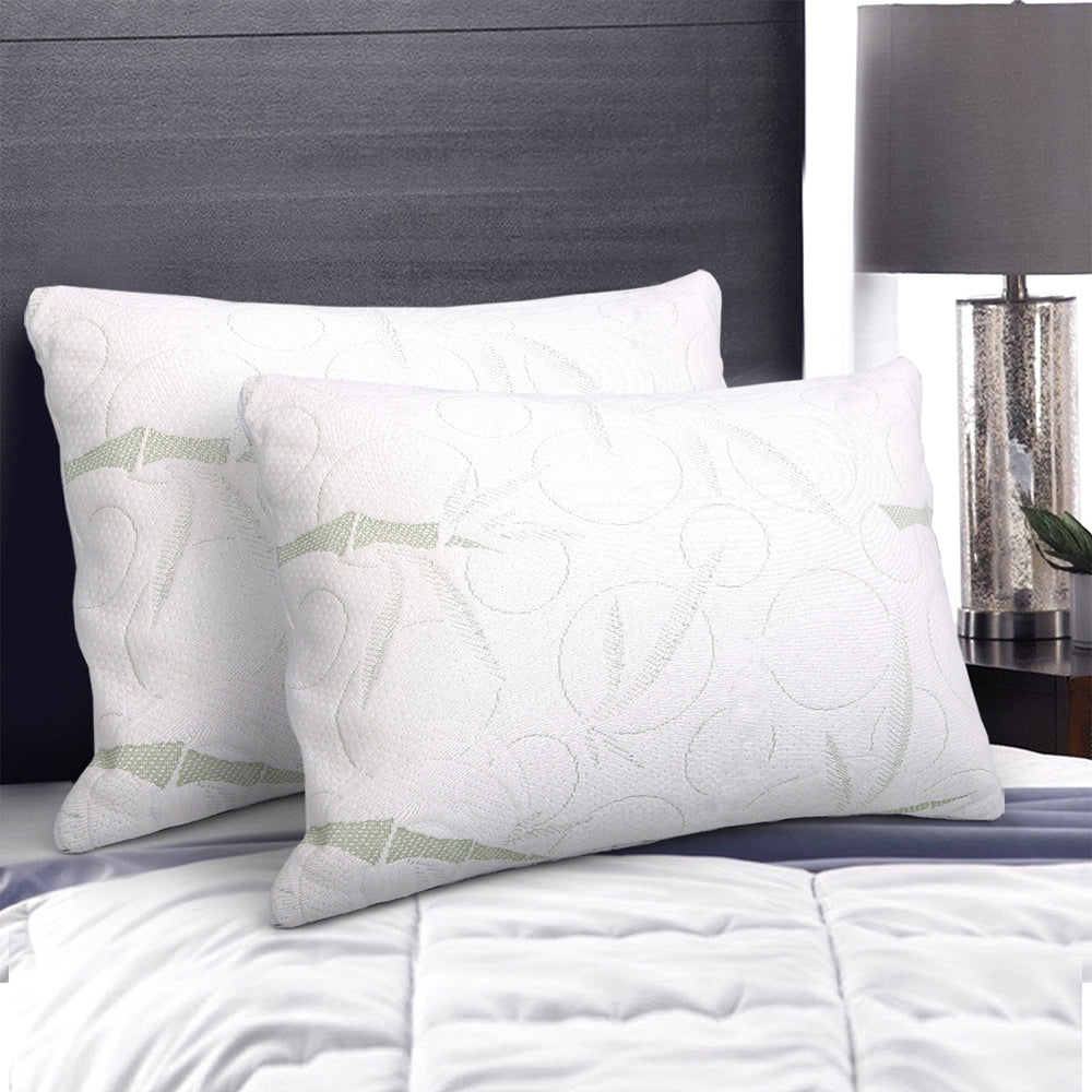 Two white pillows with subtle patterns on a bed in a bedroom setting.