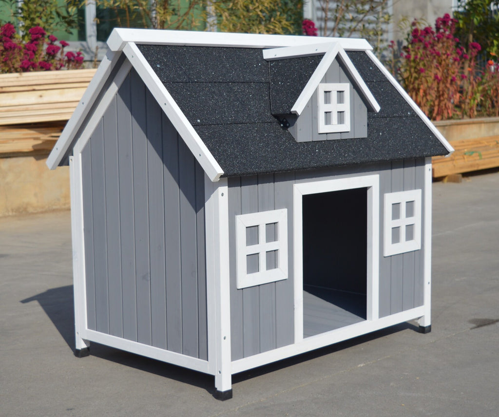 Gray and white wooden dog house with a black roof on a concrete surface.
