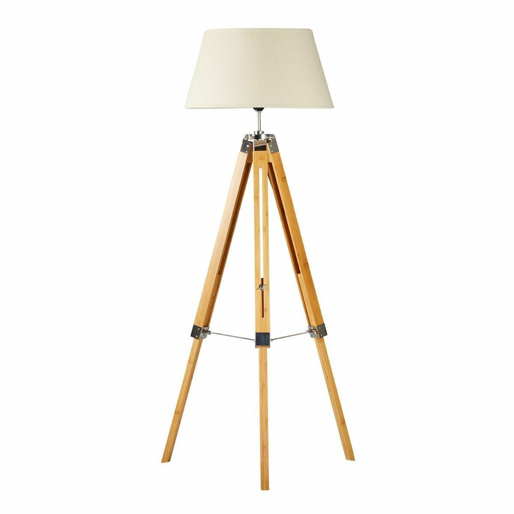 Wooden tripod floor lamp with a beige lampshade on a white background